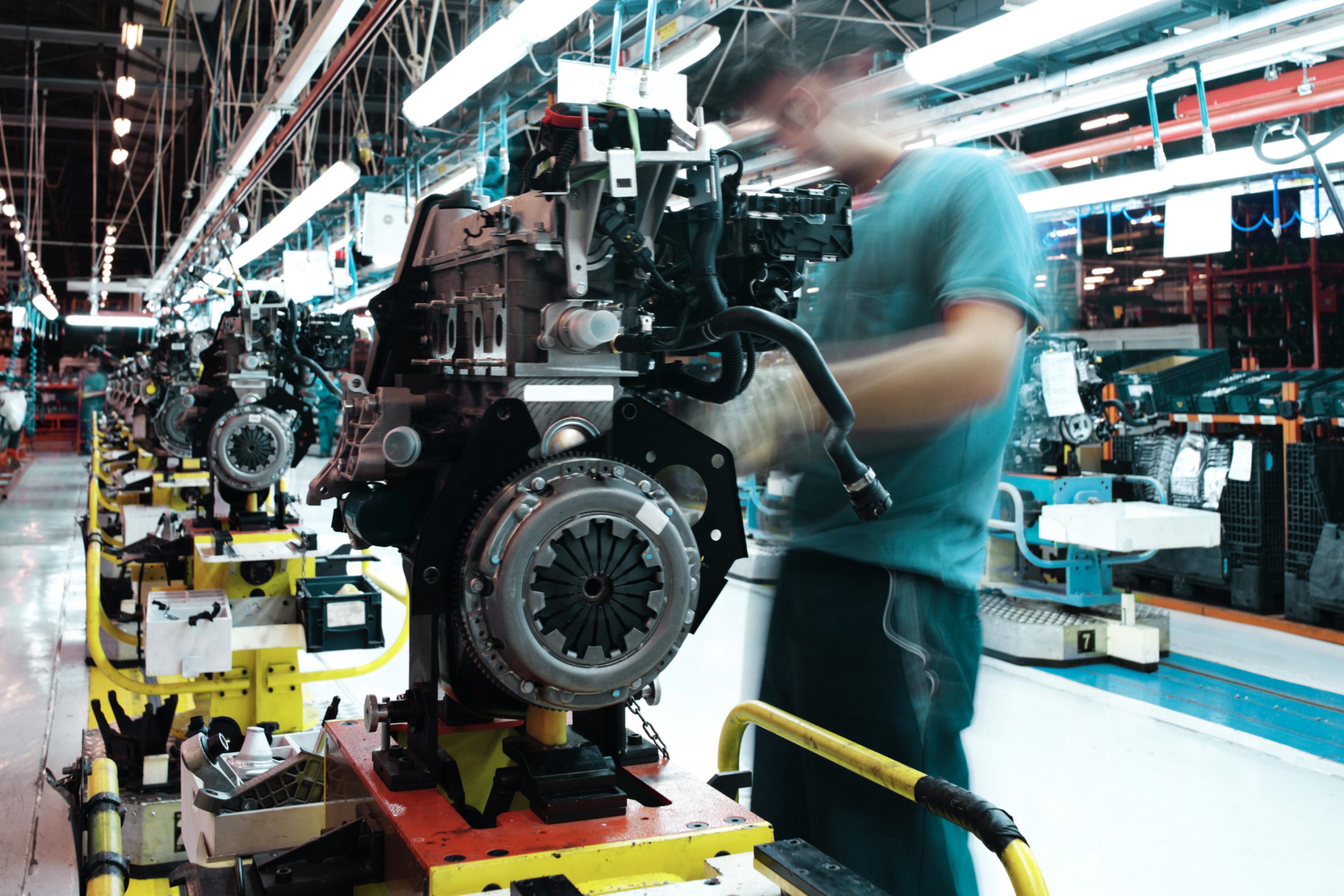 Engineer servicing machinery on an automotive production line