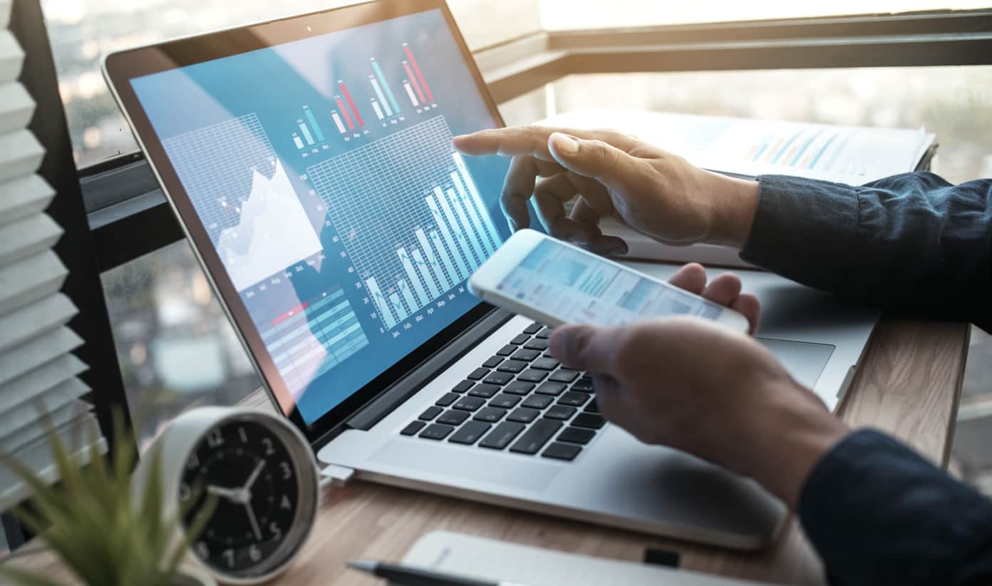 Hand pointing at analytics charts on a laptop screen