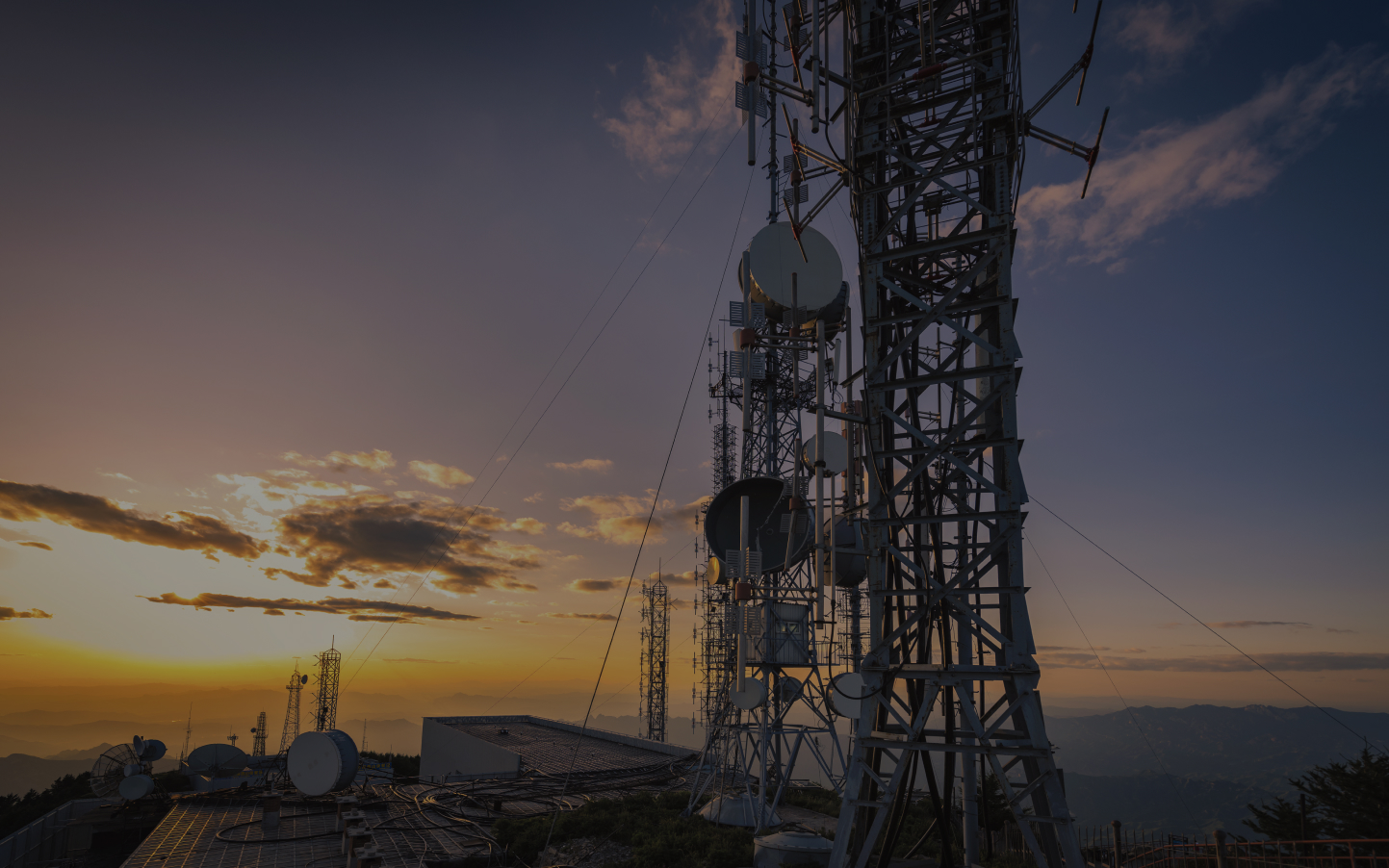 Telecom tower against a sunset sky