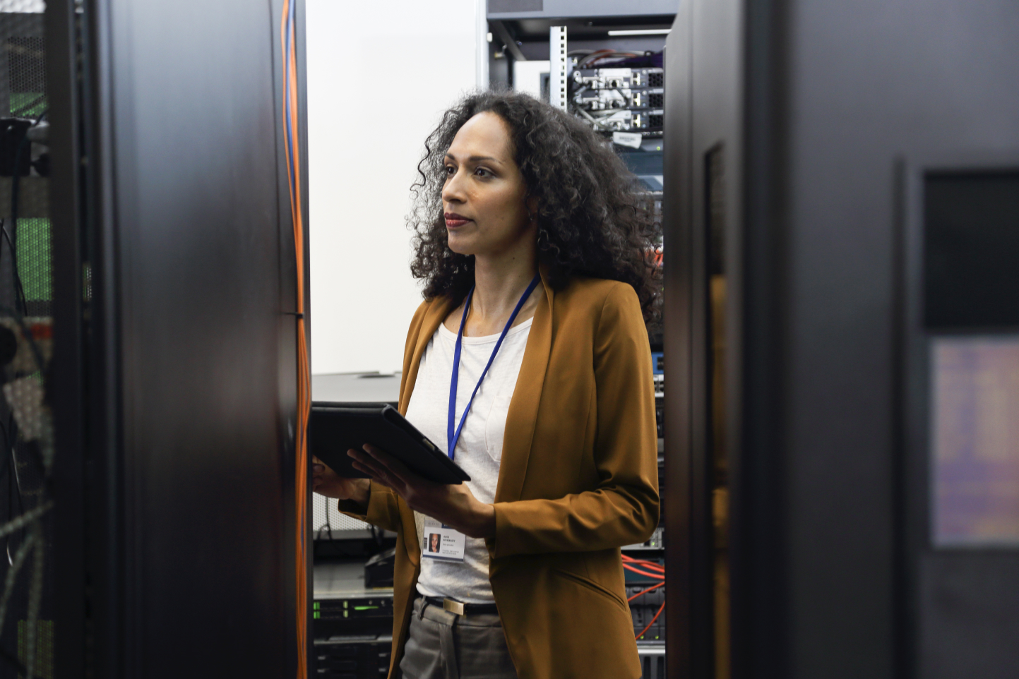 Technician checking equipment in a server room with a tablet