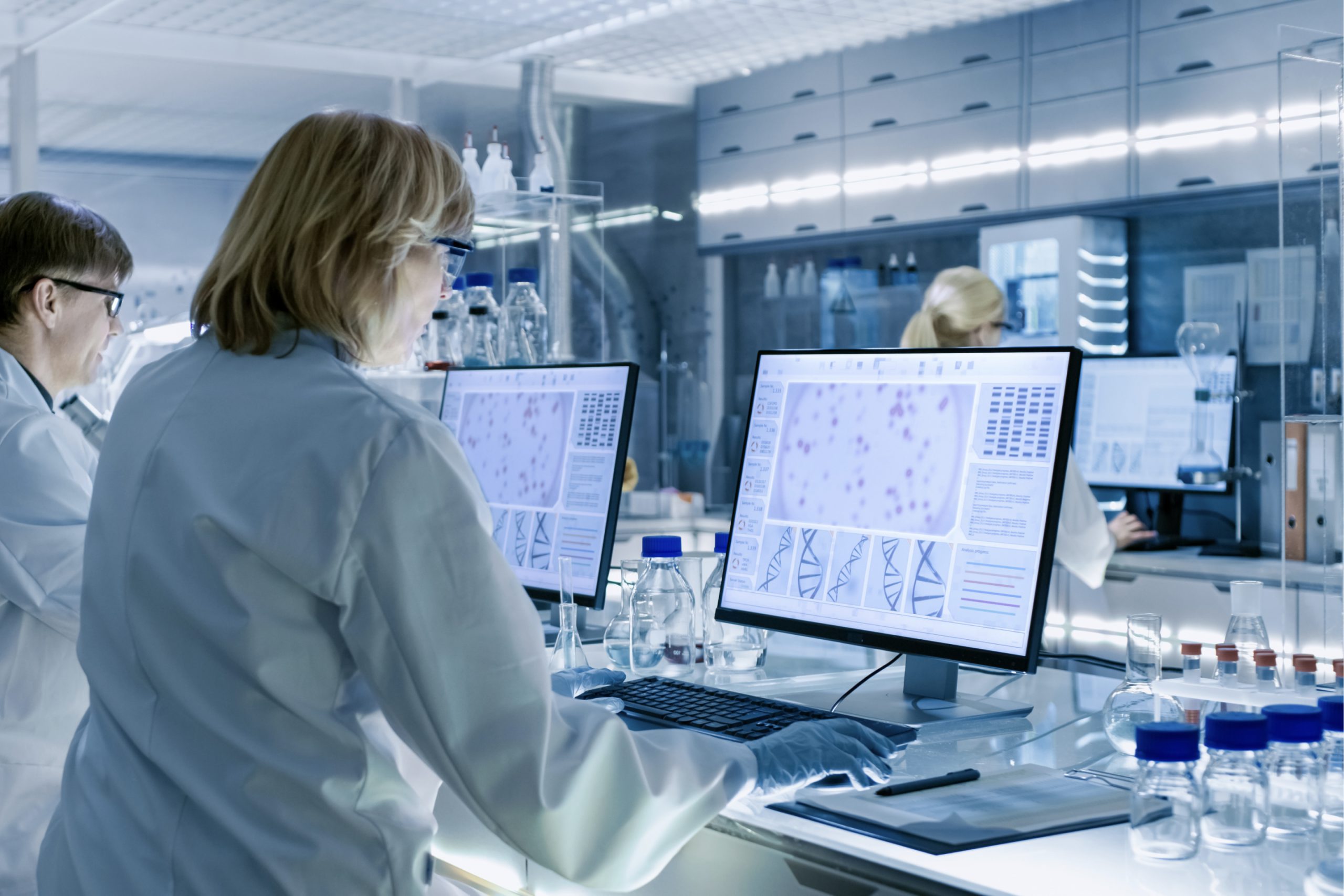 Researcher analysing data on computer screens in a laboratory