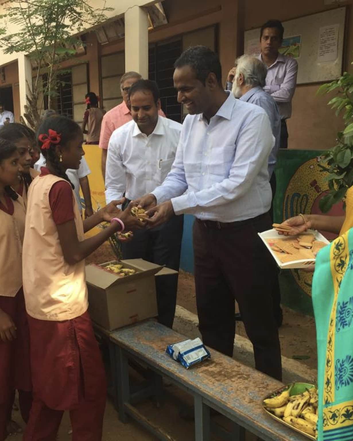 People handing out supplies to children at a community table