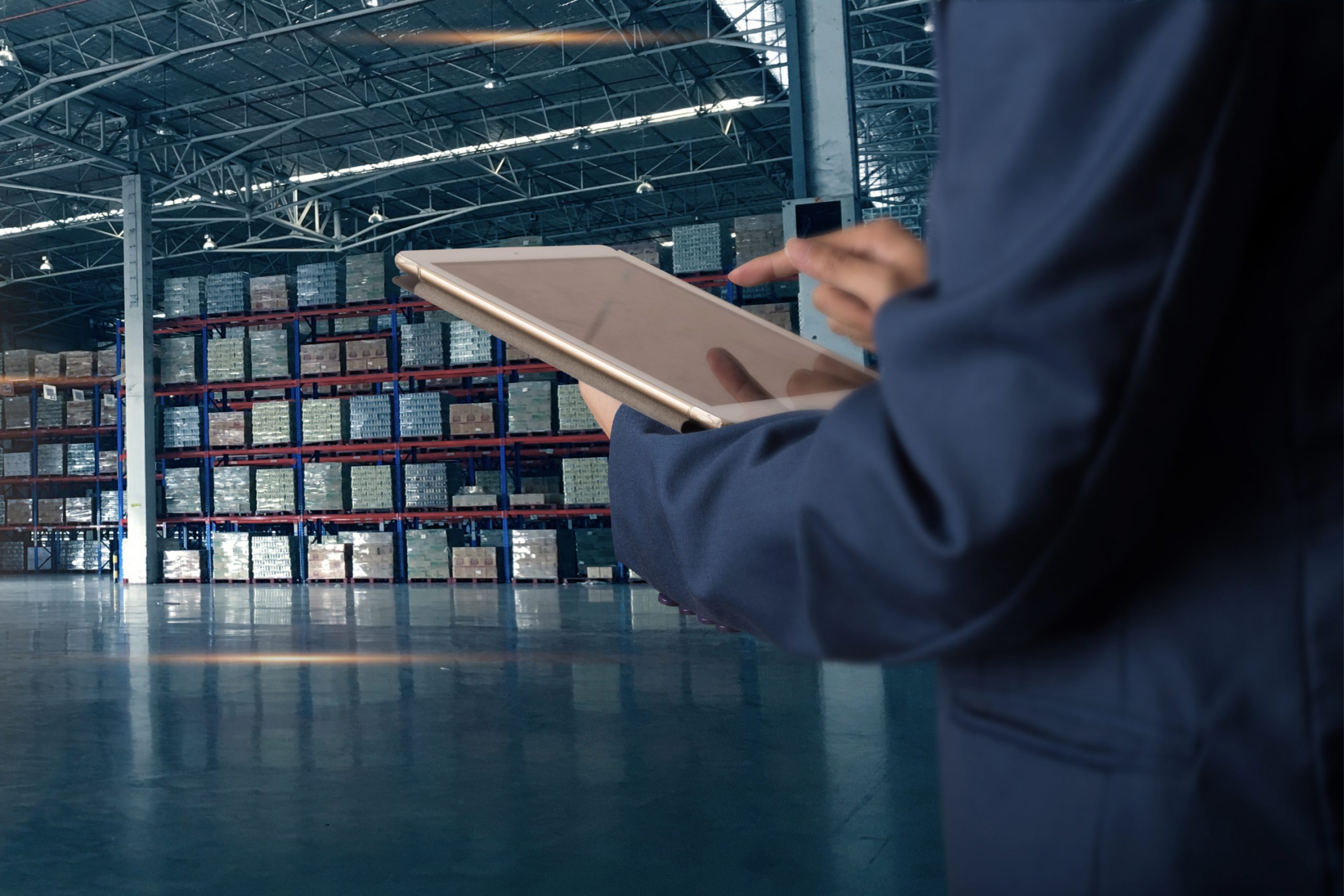 Hand holding a tablet in a warehouse