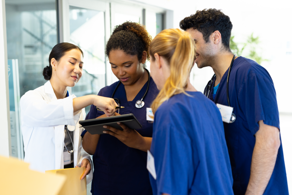 Empowering Healthcare with Technology A Journey Beyond Limitations Healthcare team in scrubs discussing with a tablet