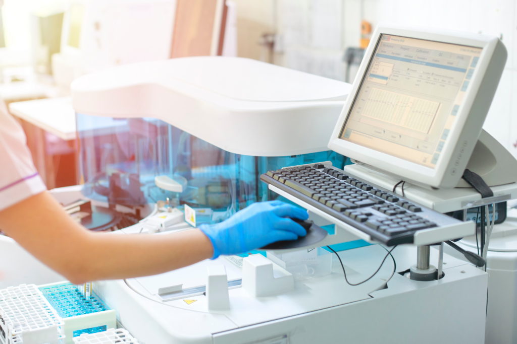 The Digital Shift in Healthcare Overcoming Legacy System Challenges Gloved hands using a computer beside a medical device