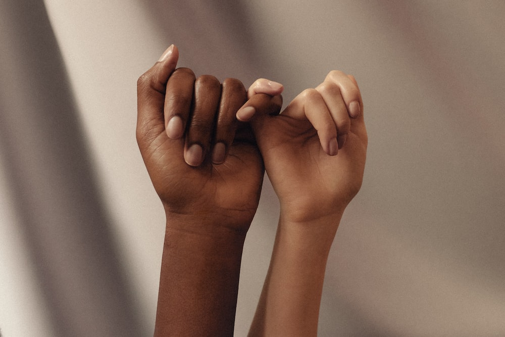 The-Importance-of-Diversity-and-Inclusion Two raised hands reaching toward each other