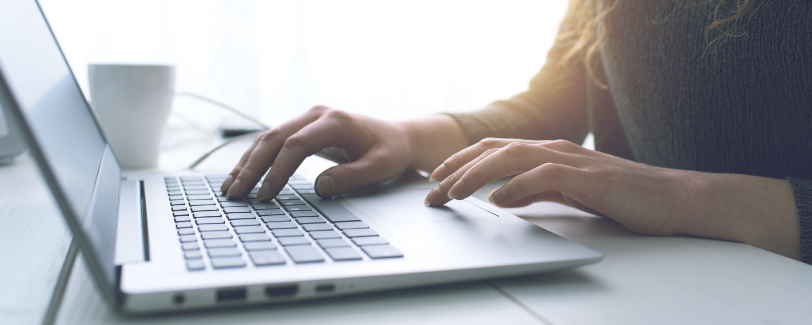 Hands typing on a laptop keyboard